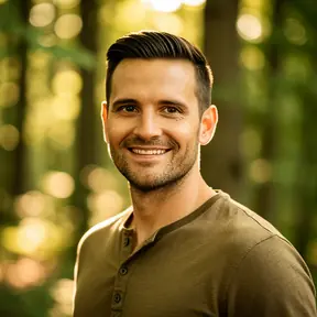 Portrait of a smiling man in his 30s outdoors in a natural forest setting, soft natural light, shallow depth of field, realistic photography, warm tones, friendly and trustworthy expression, high resolution