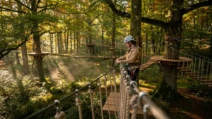 Parcours accrobranche Orne Aventure en Normandie en forêt verdoyante avec aventurière préparant son parcours